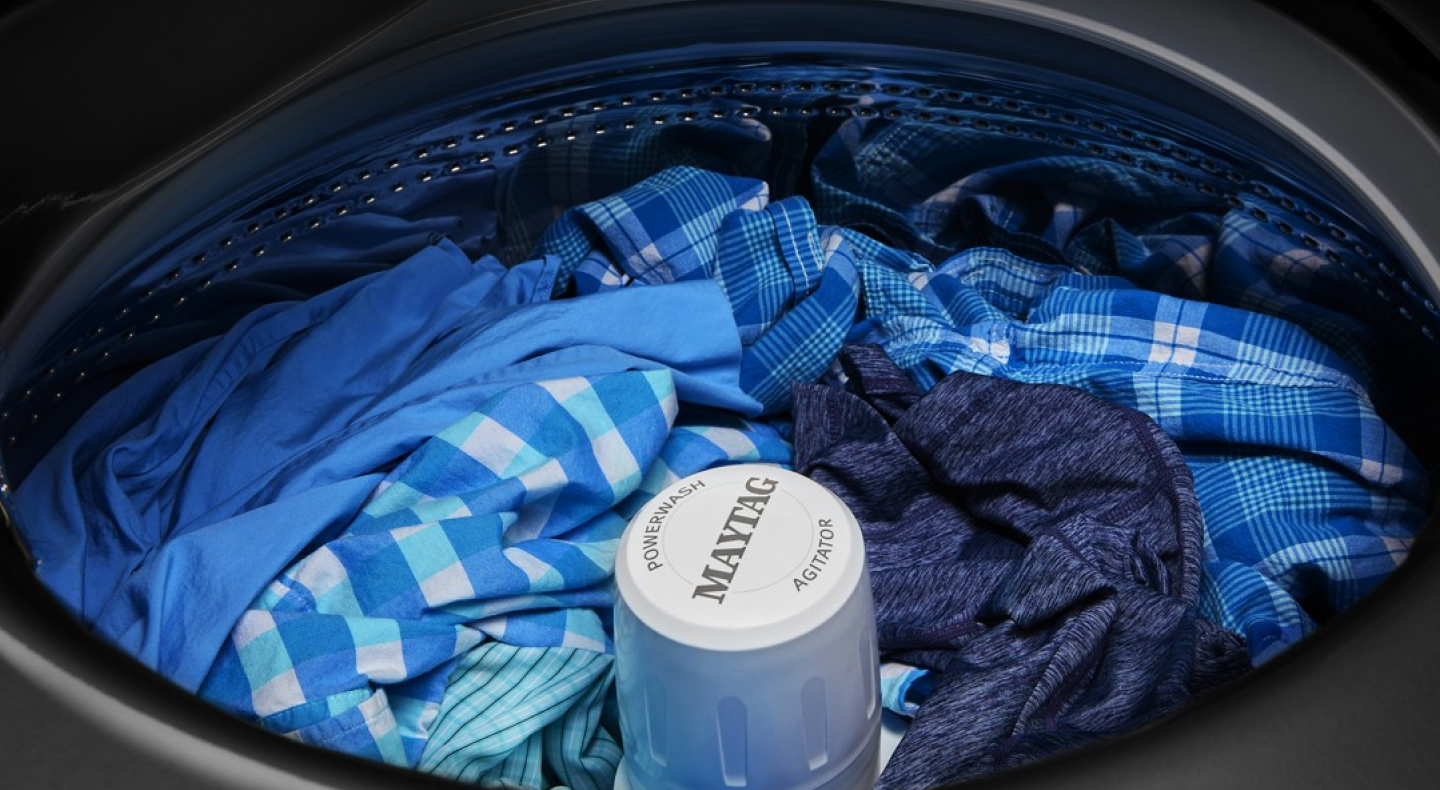 Maytag® washer filled with blue clothes