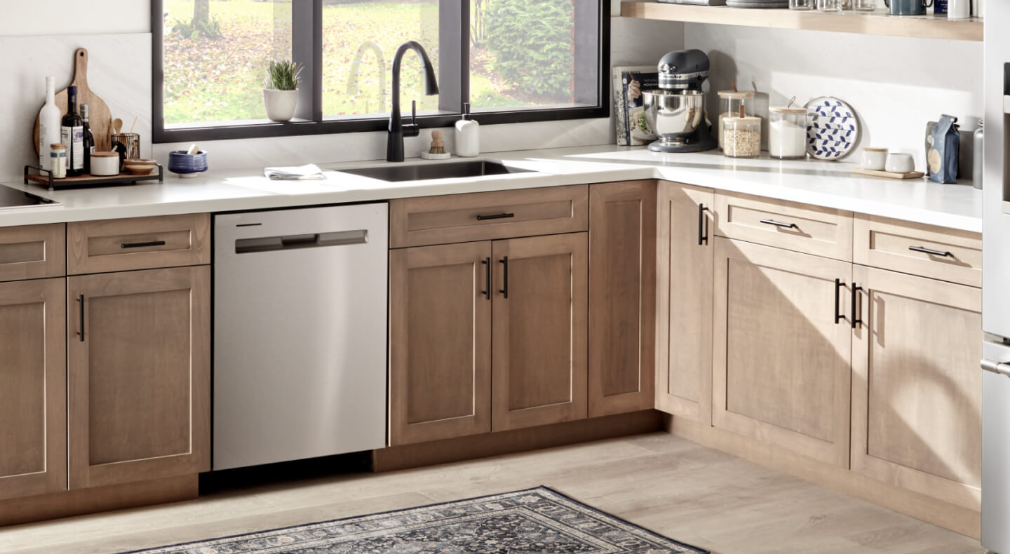 Stainless steel, pocket handle Maytag® dishwasher in brown cabinetry