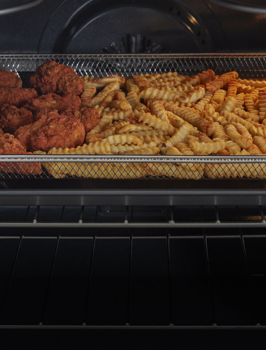 Chicken wings frying in the air fry basket.