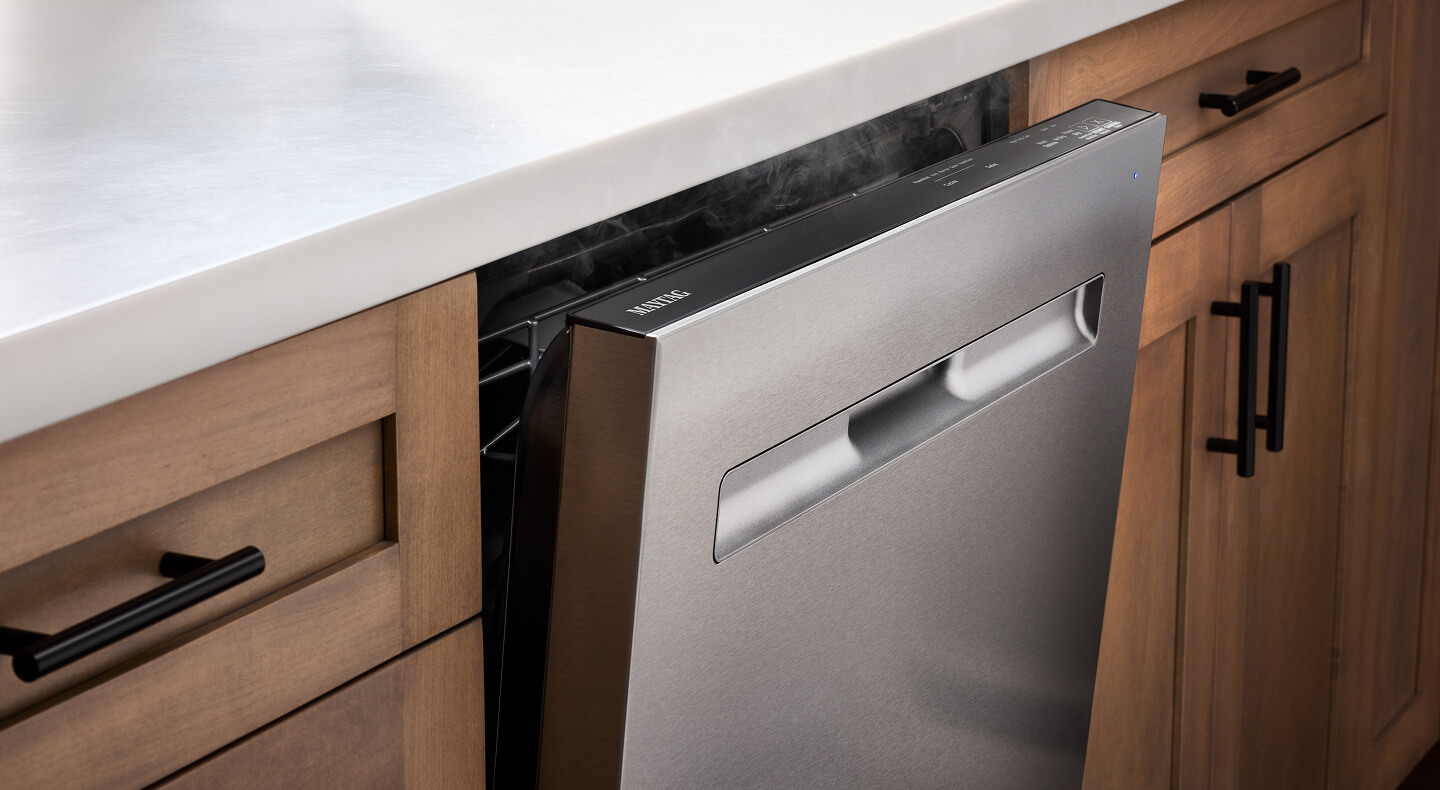 A Maytag® dishwasher with the door slightly opened