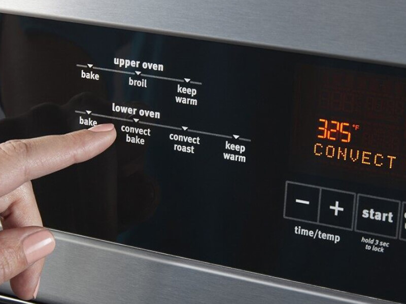 Person selecting an option on a wall oven console