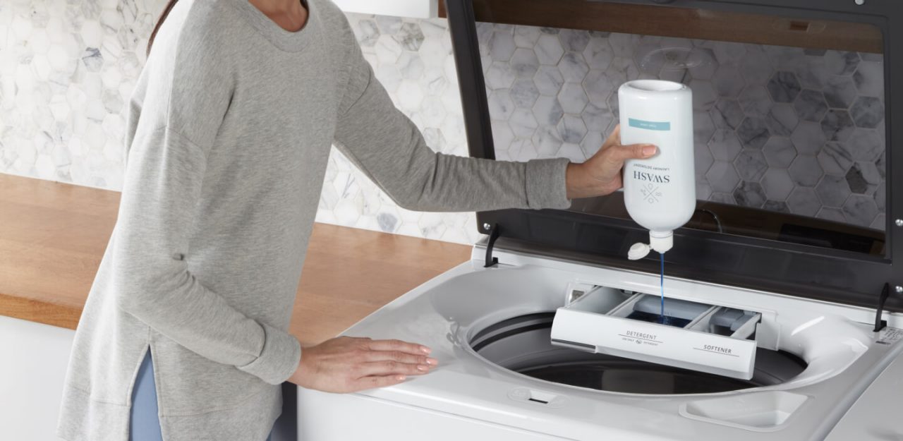 Person adding Swash® laundry detergent to the washing machine