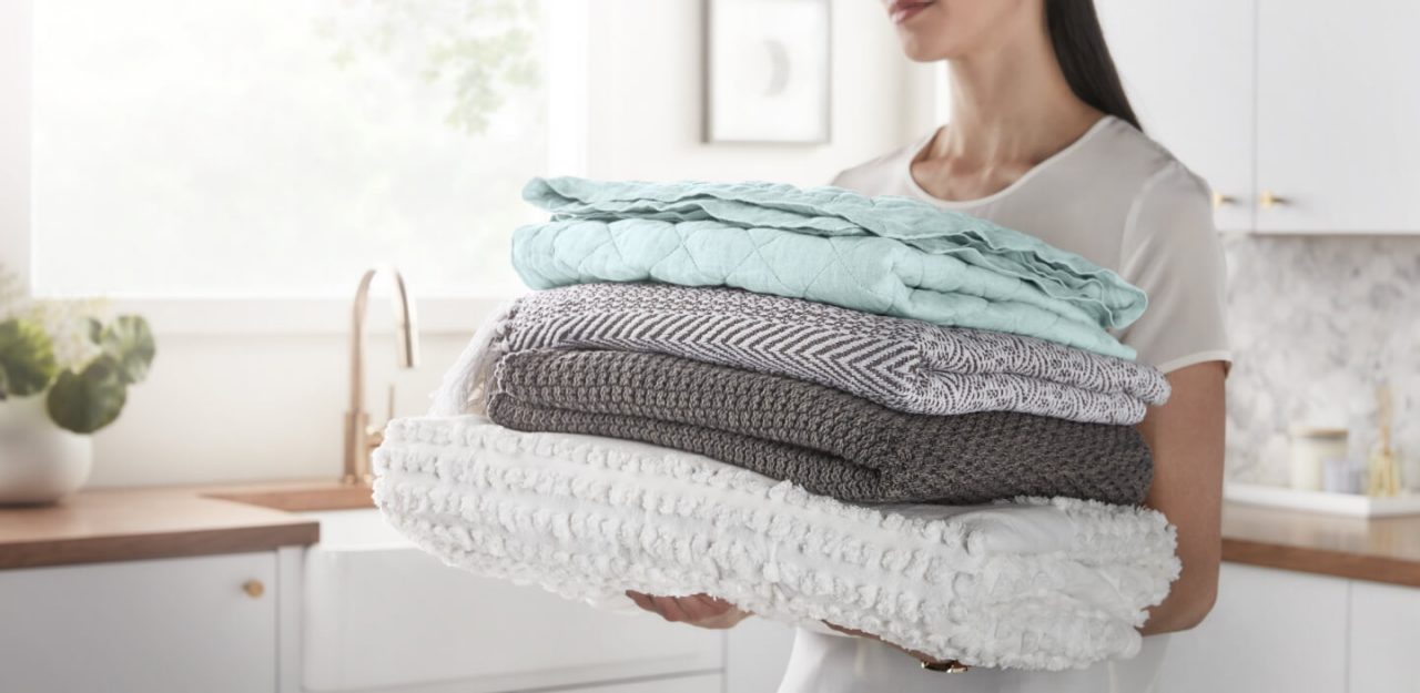 Person carrying a stack of folded towels