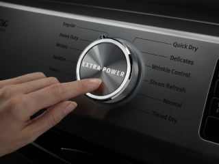 Person selecting a setting on a dryer control panel