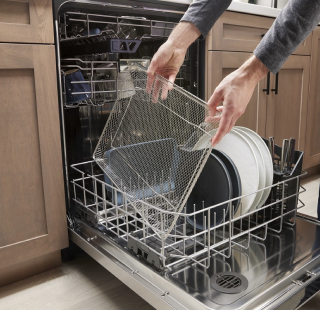 A person loading a dishwasher