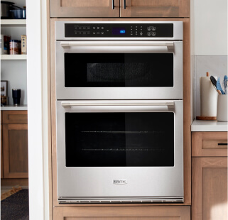 A Maytag® wall oven surrounded by brown cabinetry