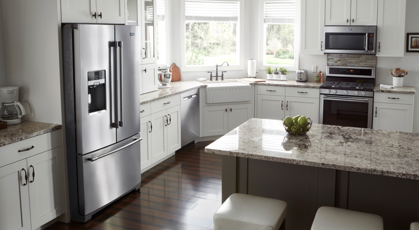 Full view of farmhouse style kitchen with stainless steel Maytag brand appliances