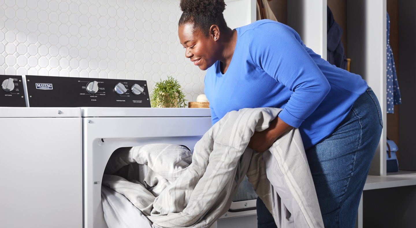 Person unloading comforter from commercial-grade dryer