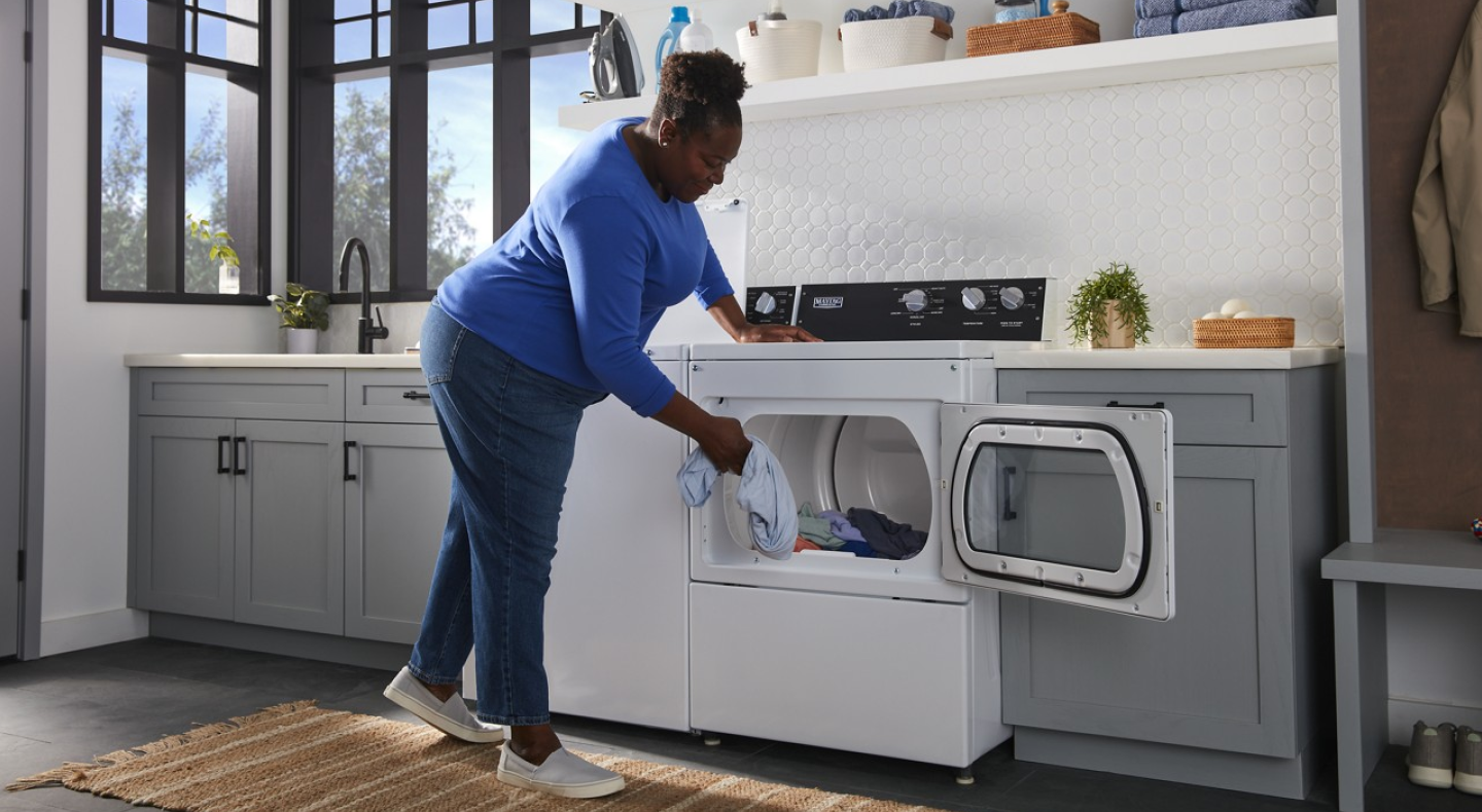 Person loading clothes into a commercial-grade dryer