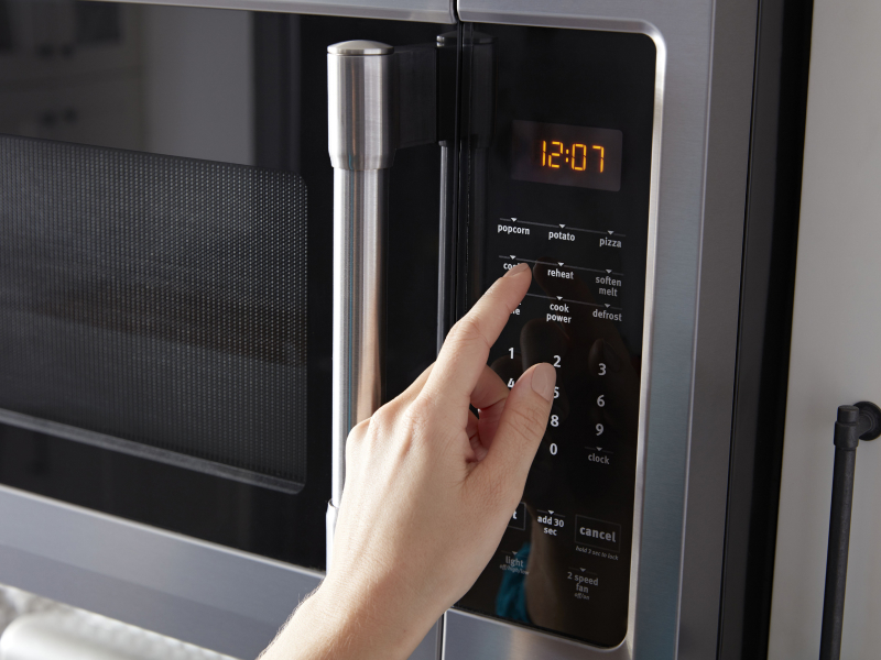 Person selecting settings on a microwave control panel