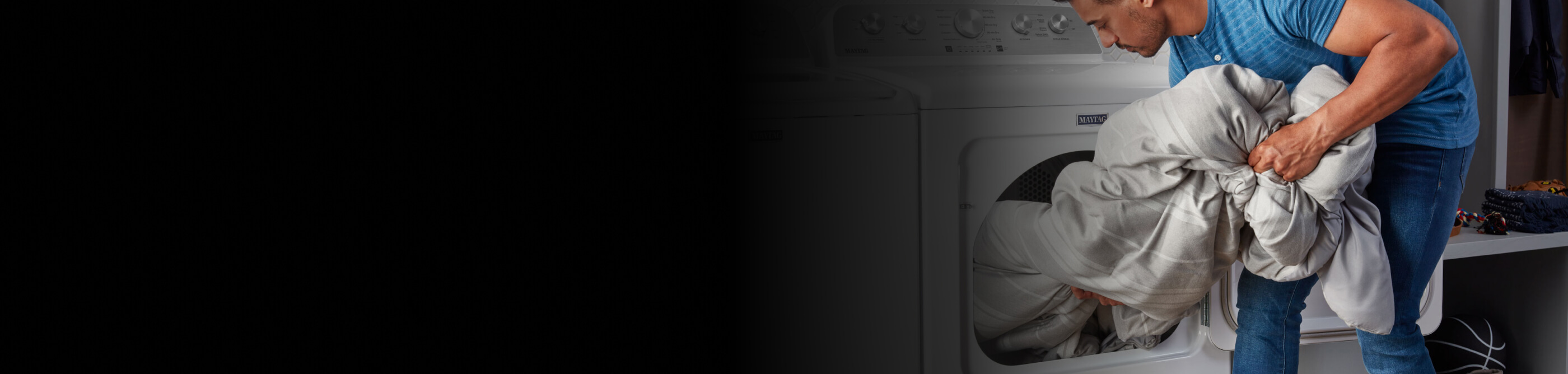 A person loading a comforter into a Maytag® front-load dryer