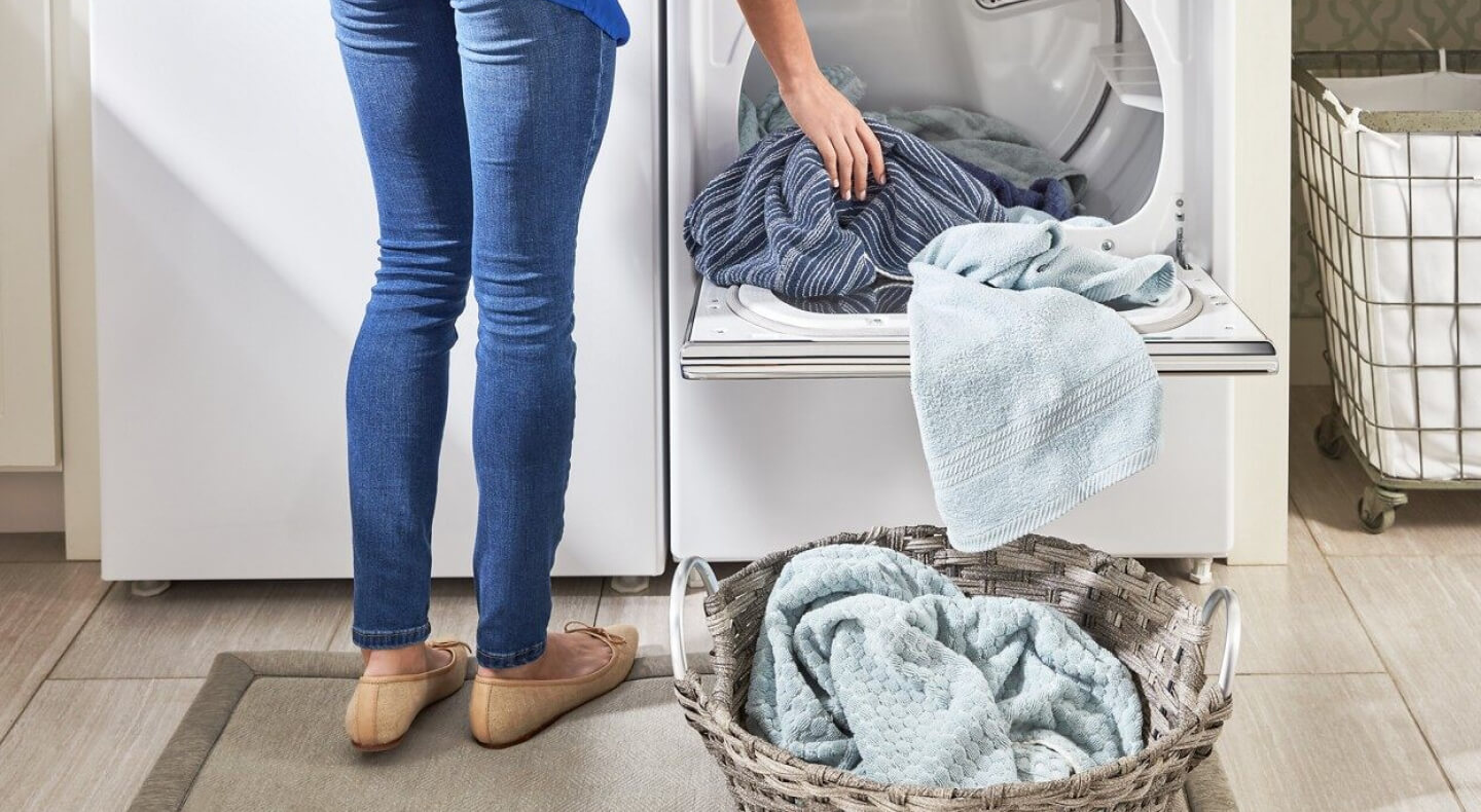 A woman unloading dry laundry into a basket