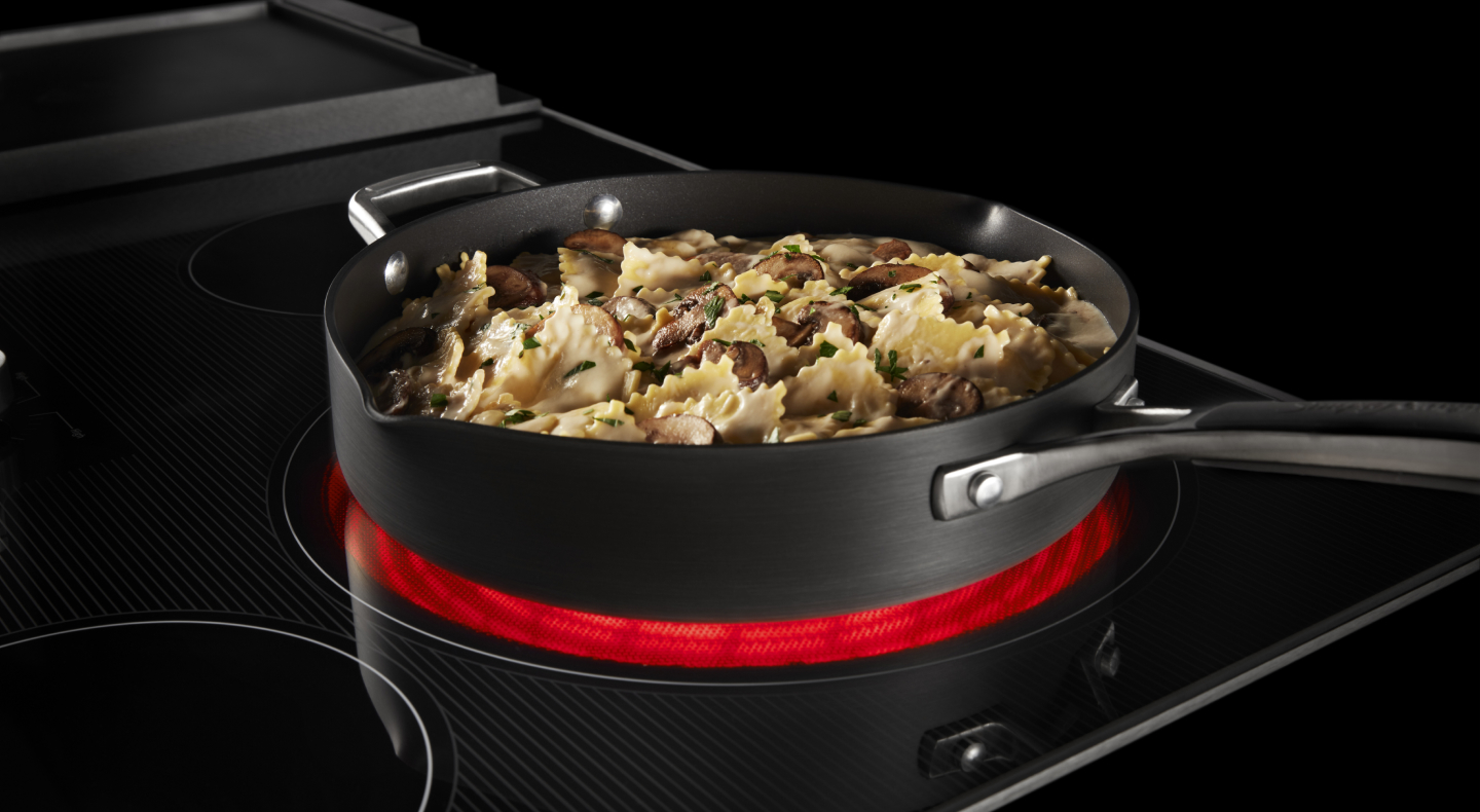 A pasta dish cooking on a heating element