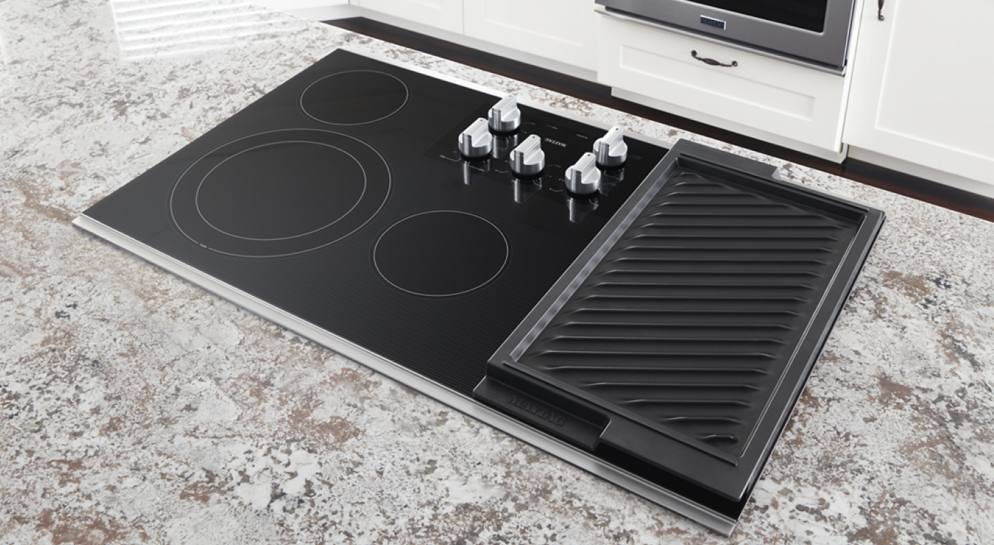 Black Maytag® glass cooktop installed on a granite countertop