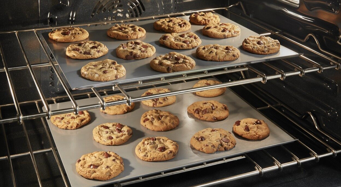 Two sheets of cookies in the open oven