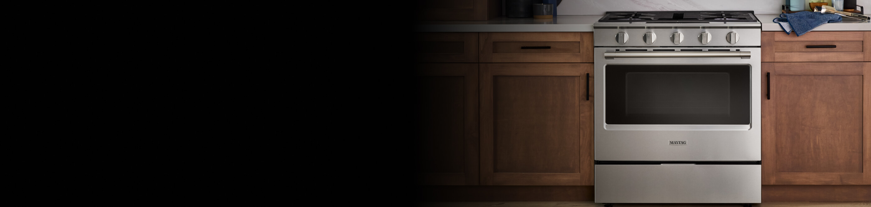 Stainless steel Maytag® gas range in modern wood cabinetry