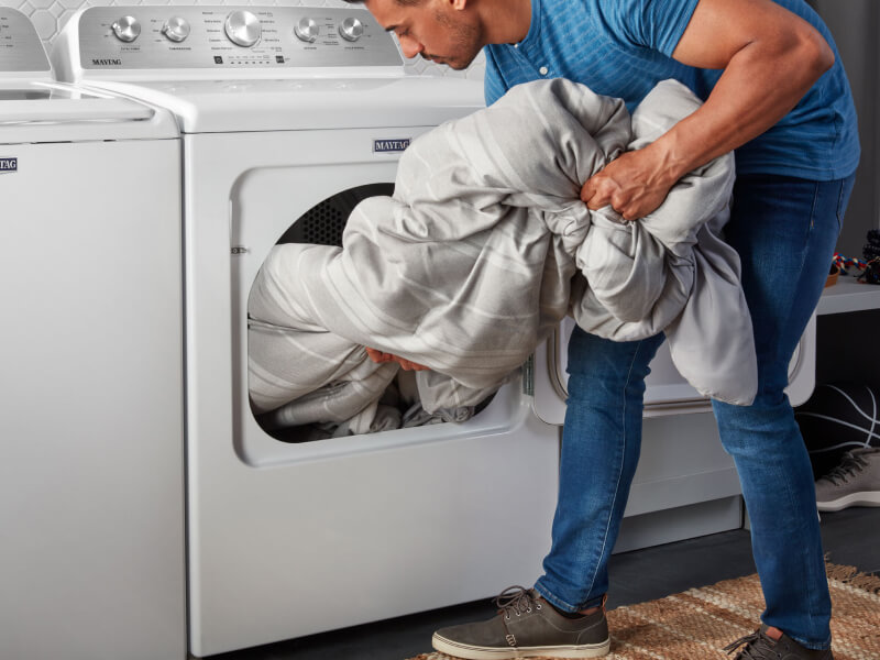Person removing laundry from a Maytag® dryer
