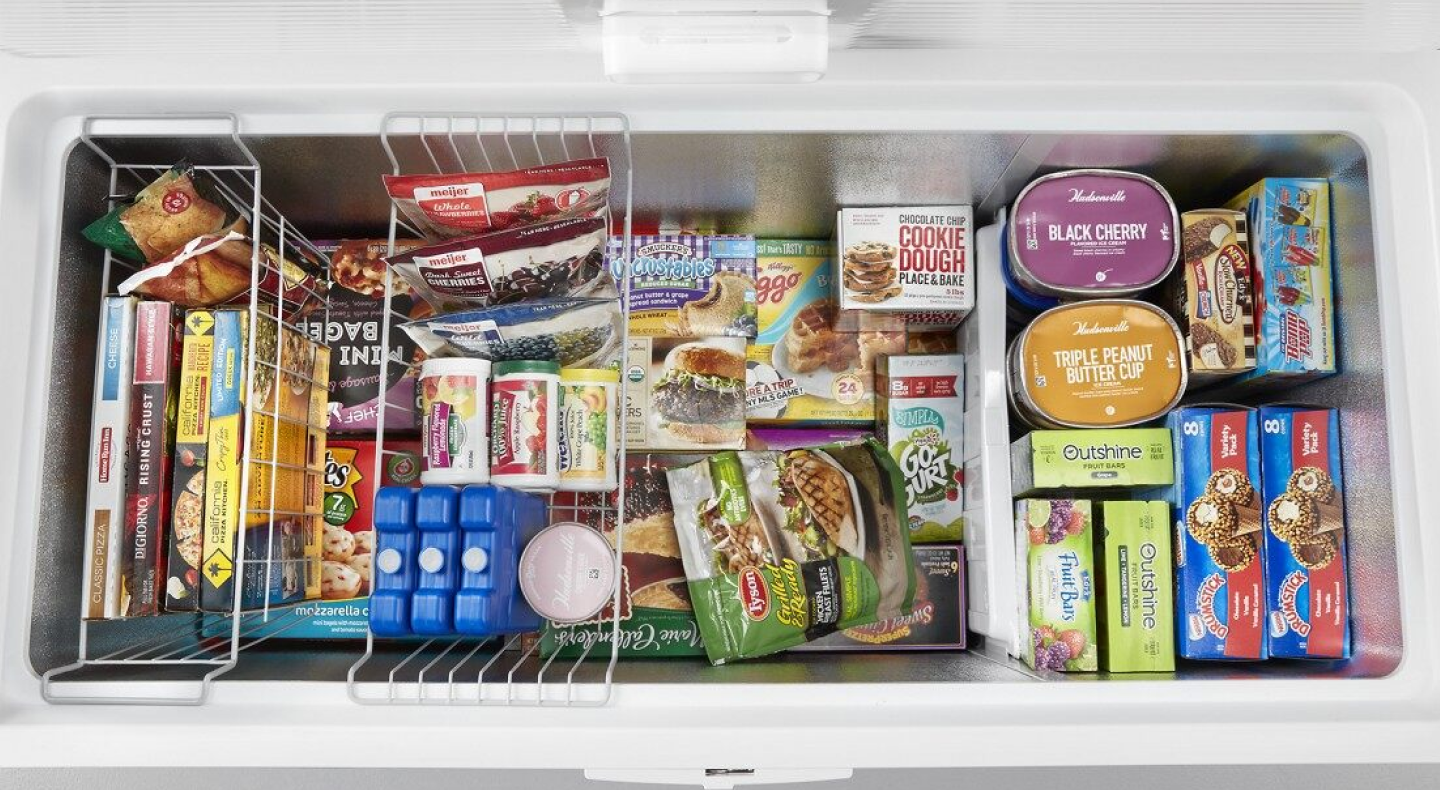 Birds-eye view of a chest freezer full of organized frozen food