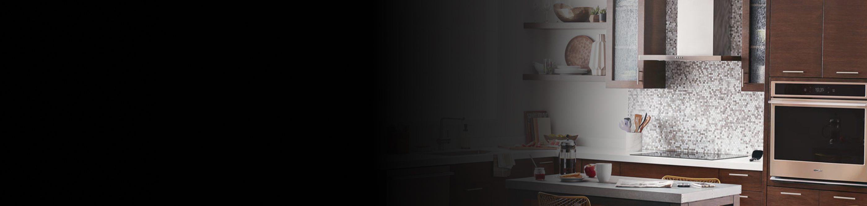 Range hood above an electric stovetop in front of a tile backsplash