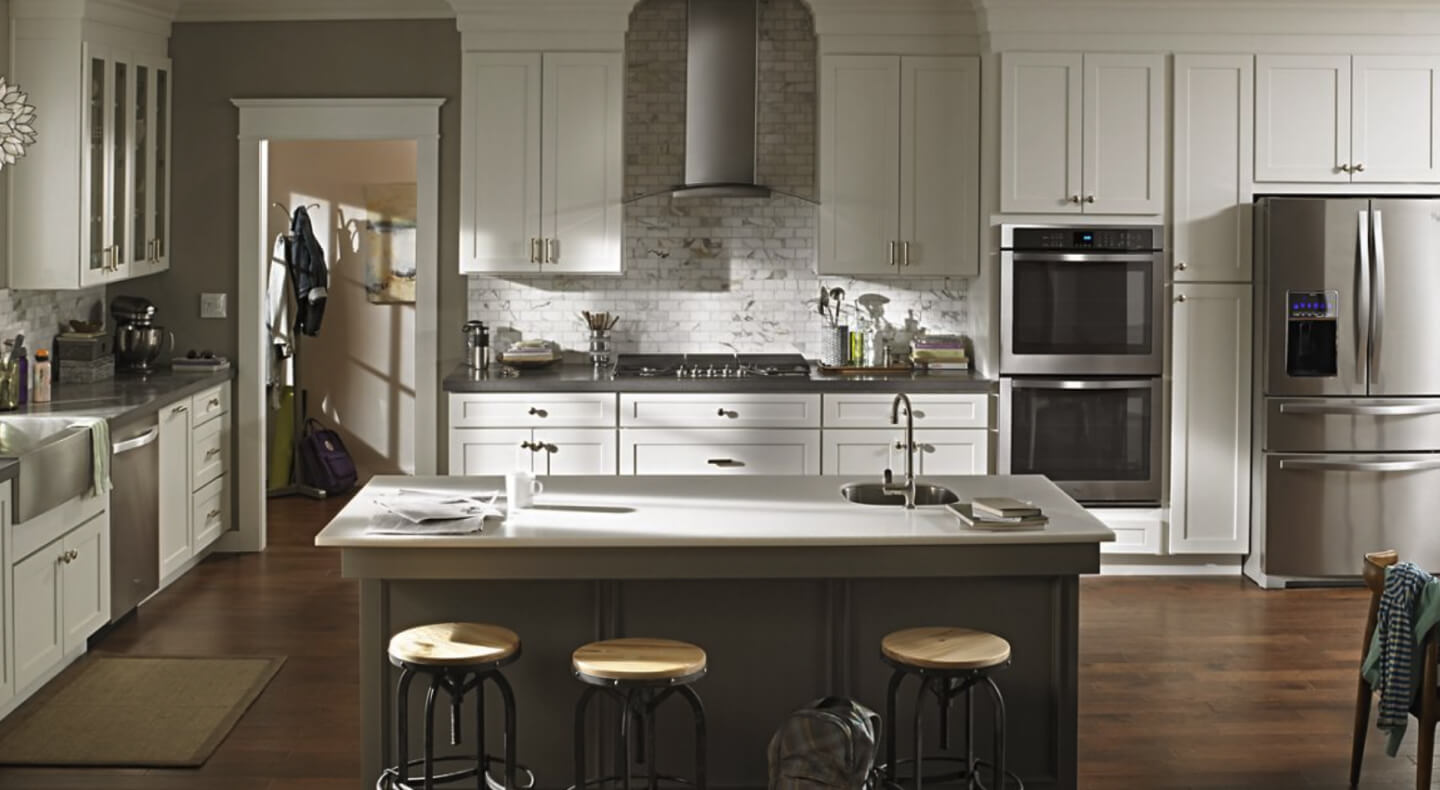 Wall mount range hood in kitchen with stainless steel appliances