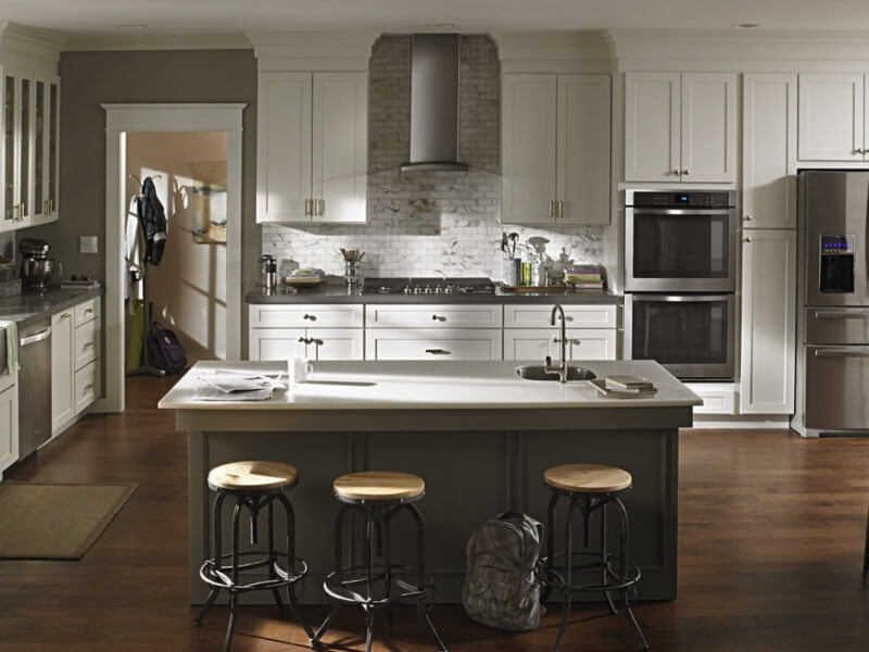 Wall mount range hood in kitchen with stainless steel appliances