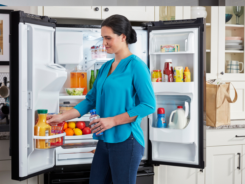 Person putting items in a refrigerator