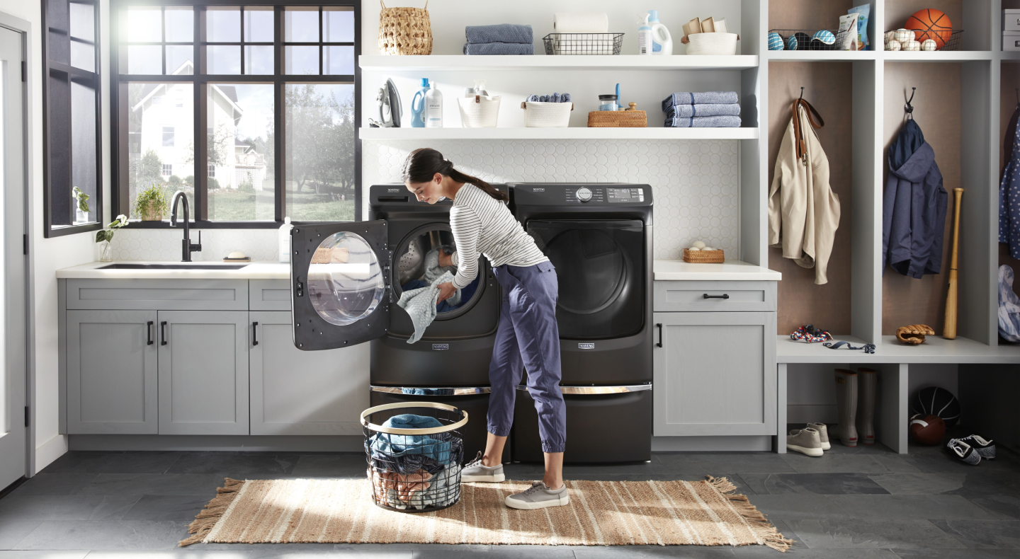 Person taking laundry out of a Maytag® front load washer