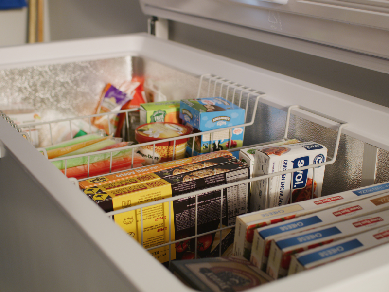 Close-up of chest freezer storage baskets full of food