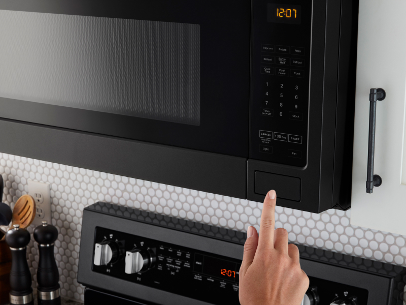 Person selecting a microwave setting on a Maytag® microwave