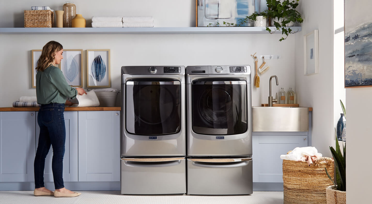 Person standing next to Maytag® laundry pair.