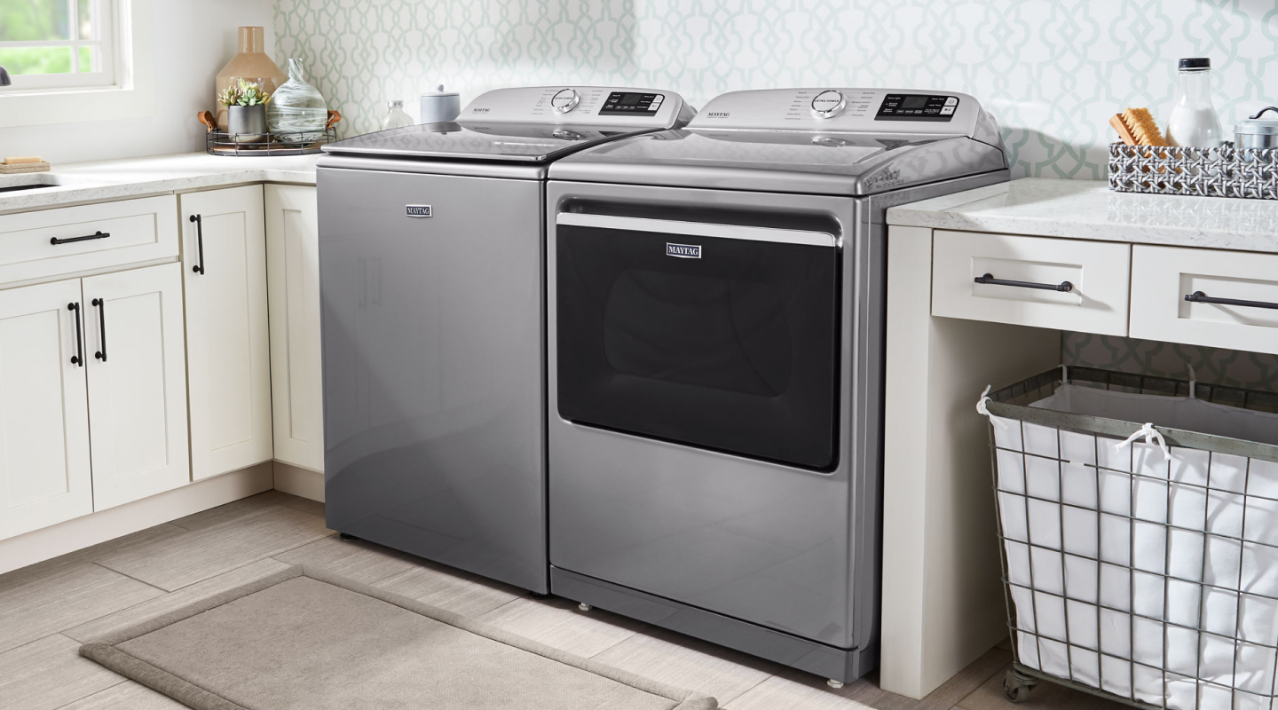 Maytag® top loading washer and dryer in a laundry room