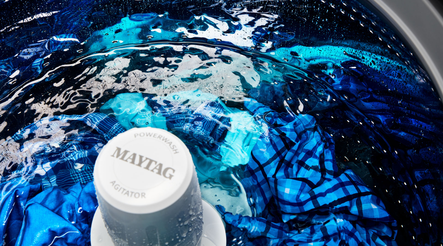 Clothes in a wash cycle inside a Maytag® top load washer