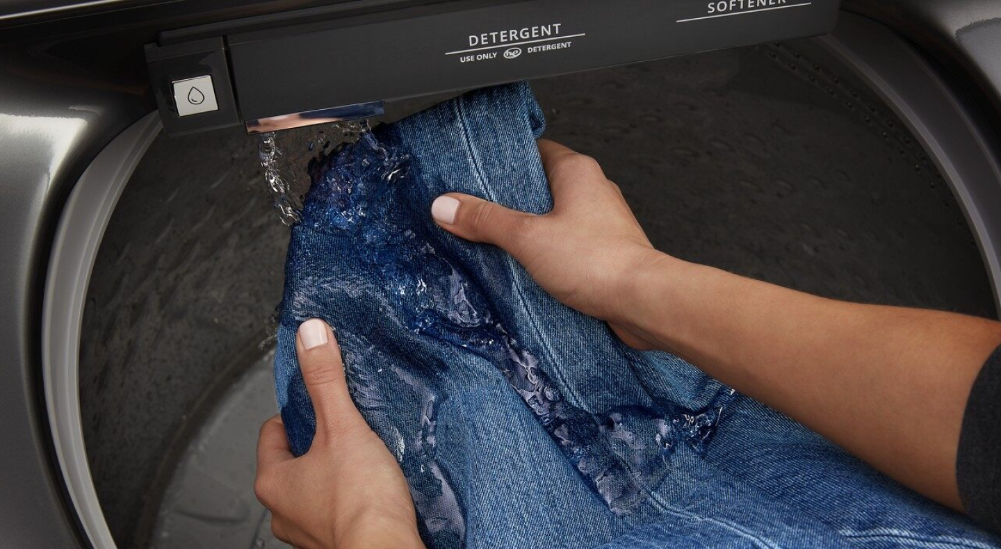 Hands pretreating denim with a built-in faucet