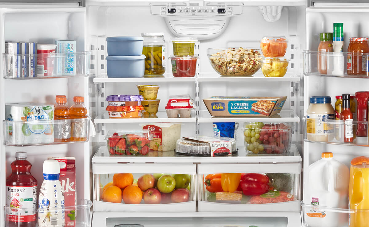 An open French door refrigerator filled with various foods