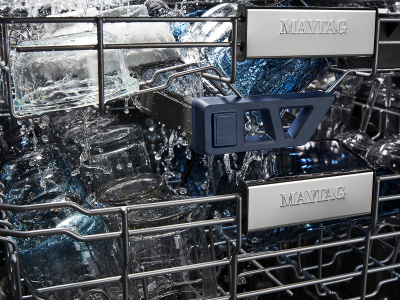 Filled racks of a Maytag brand dishwasher during a cycle. 