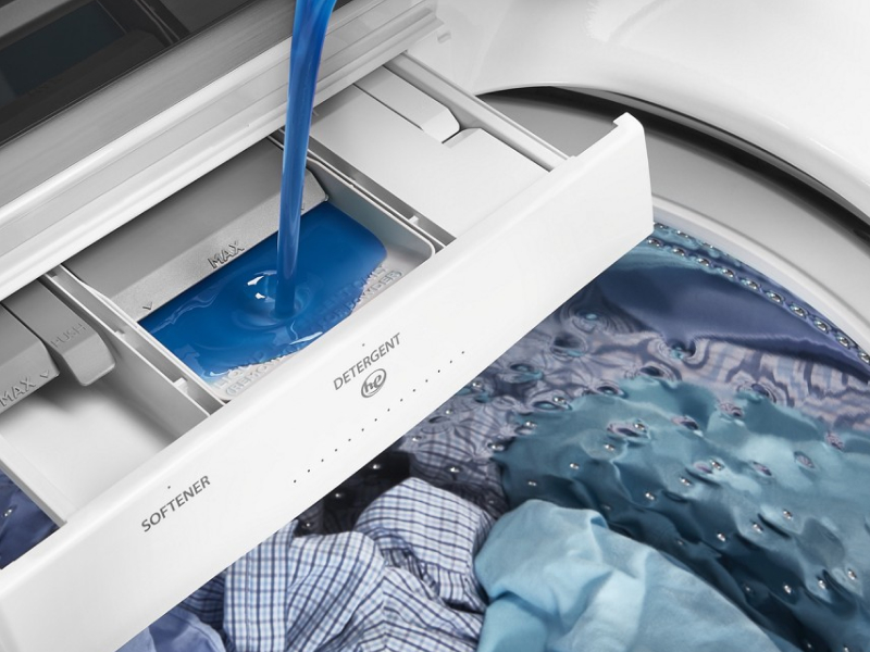 Detergent being poured into a washer detergent dispenser