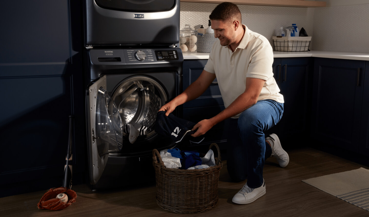 Person loading clothes into front load Maytag® washer