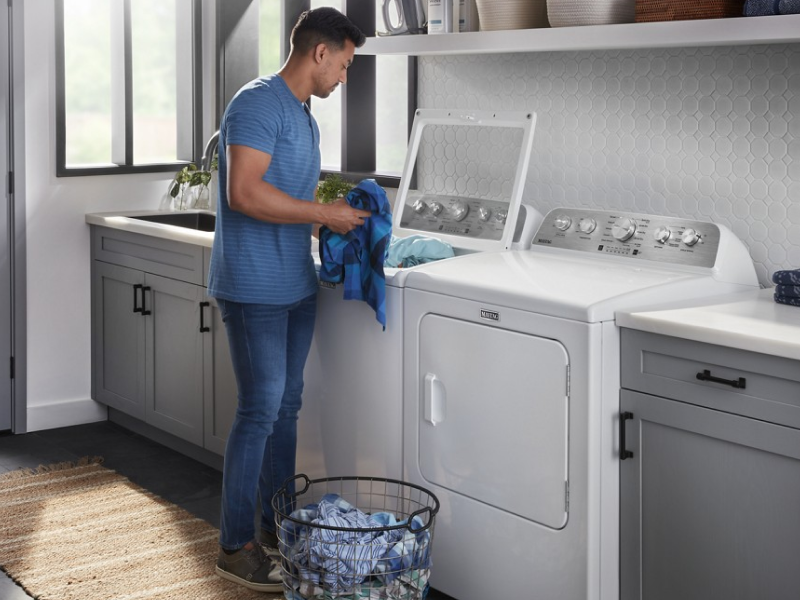 Person putting clothing in washing machine
