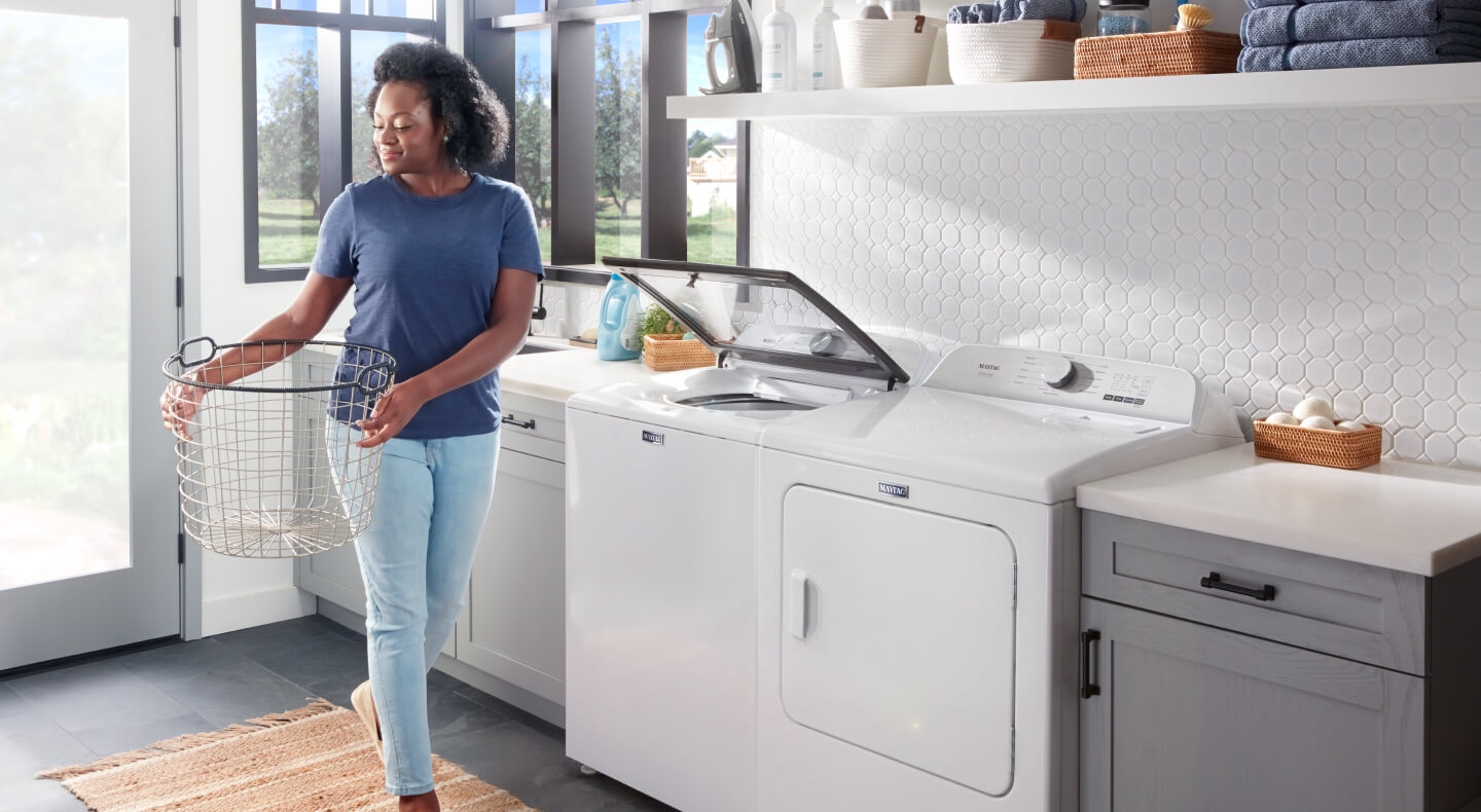 Person walking into a laundry room with a laundry basket