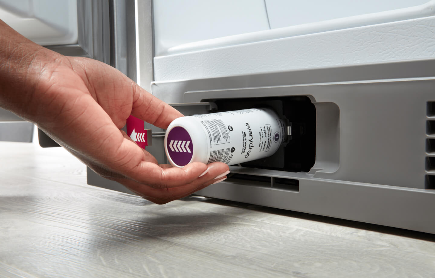 Person inserting an everydrop® water filter into their refrigerator