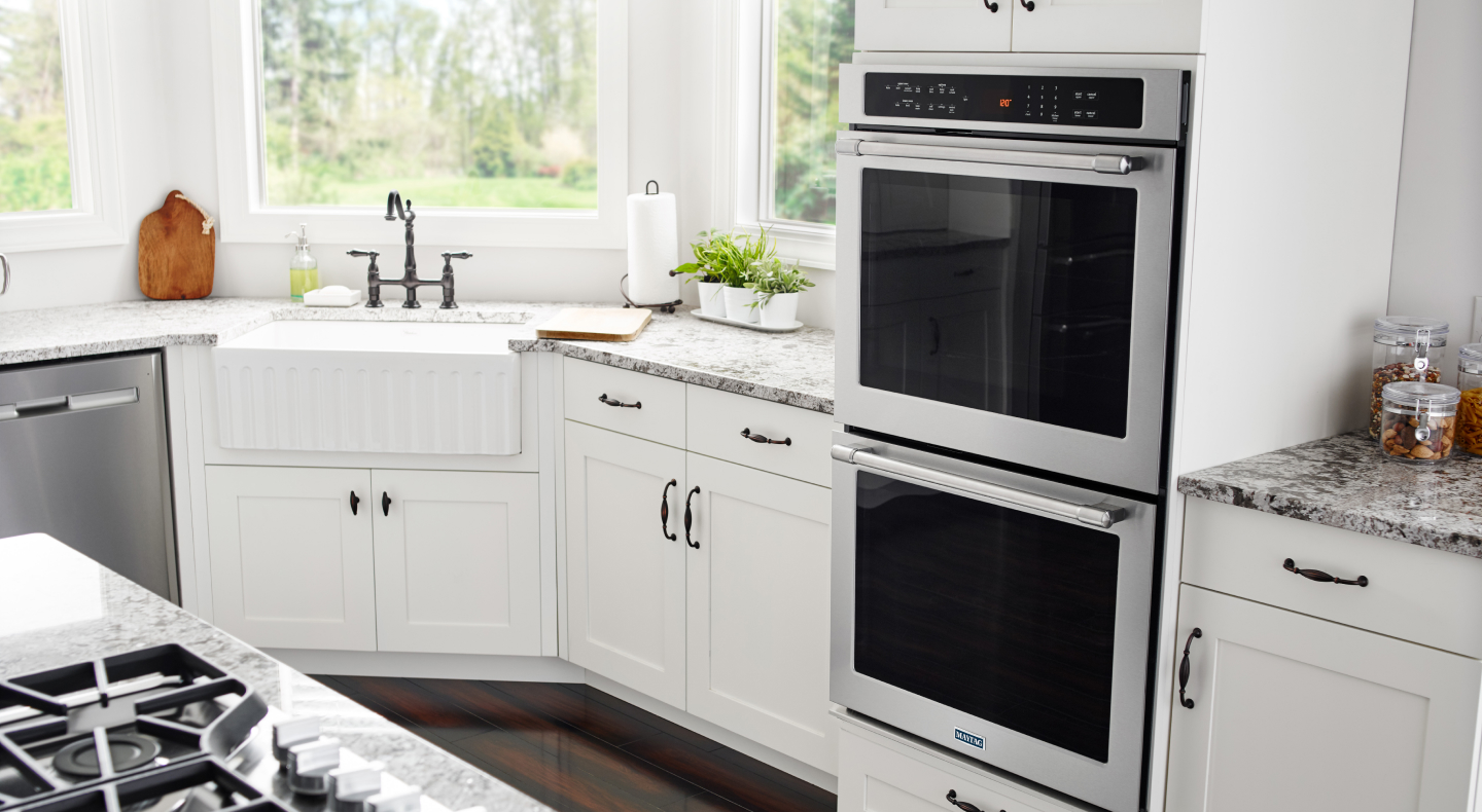 Double wall oven from Maytag brand in kitchen with white cabinetry