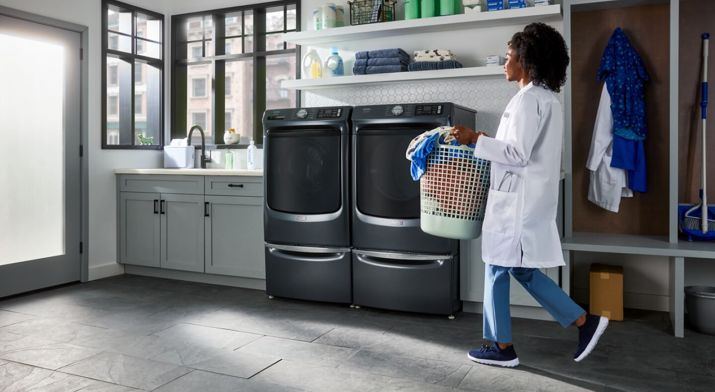 Person in laundry room with Maytag® front load laundry pair