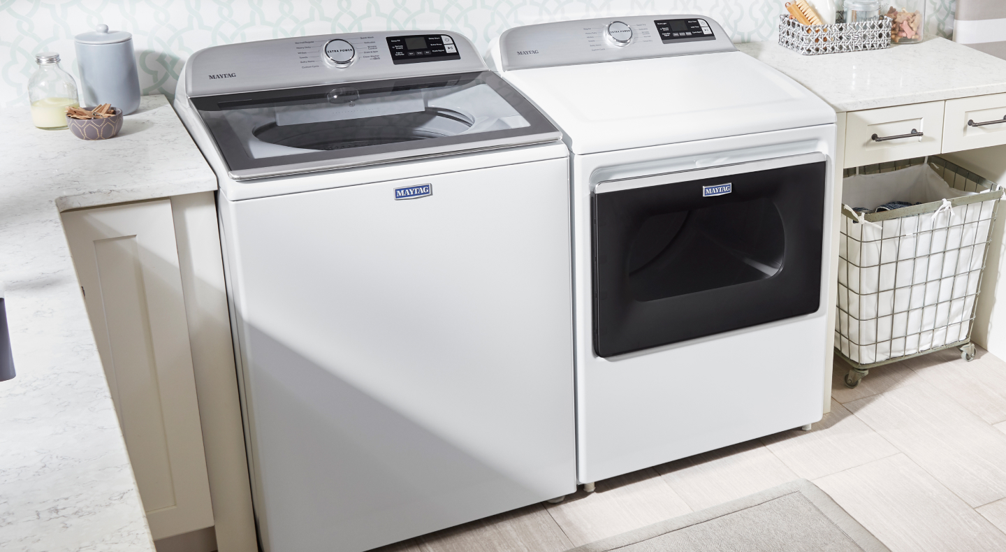 White Maytag® top load washer and dryer set in a bright laundry room