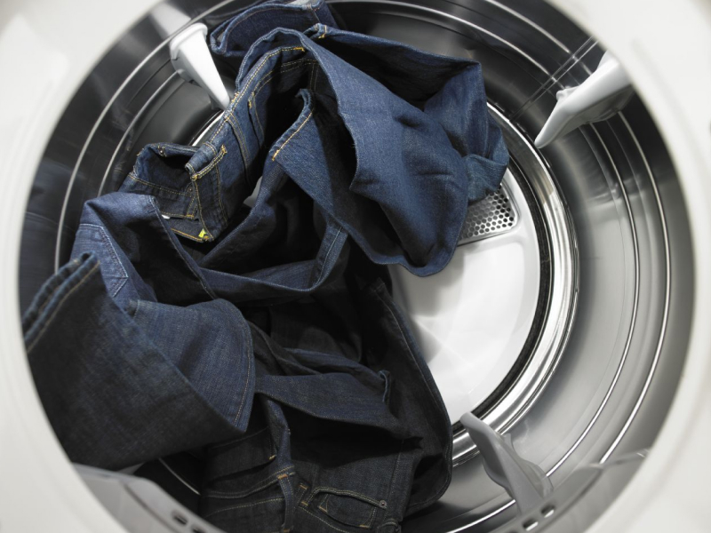 Jeans tumbling inside a dryer