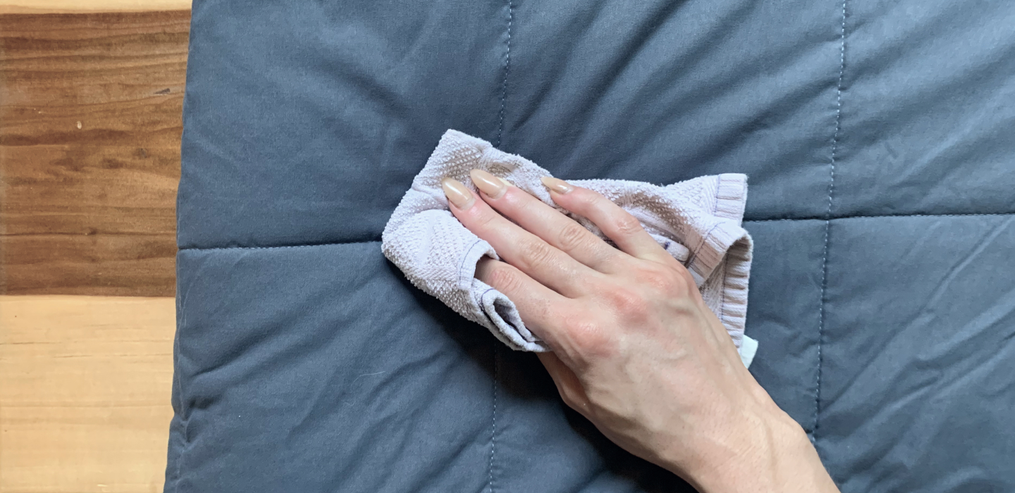 Rag in hand wiping weighted blanket