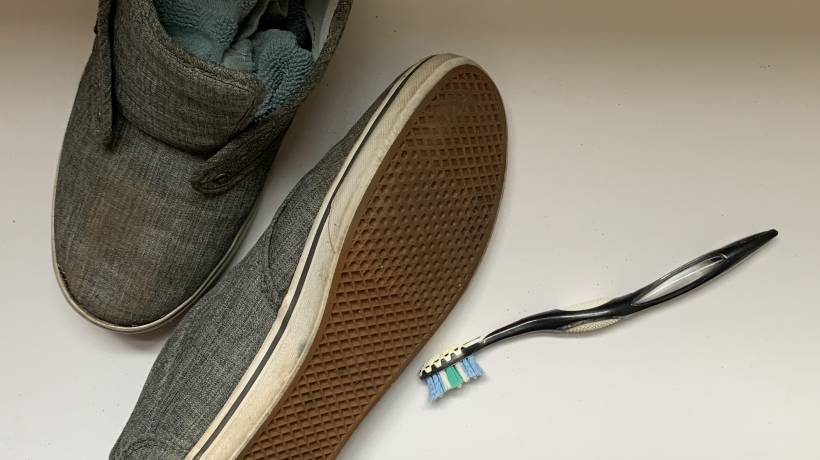 Shoes stuffed with rags next to a toothbrush 