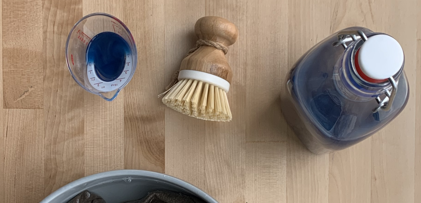 Bristle brush and measuring cup filled with liquid detergent