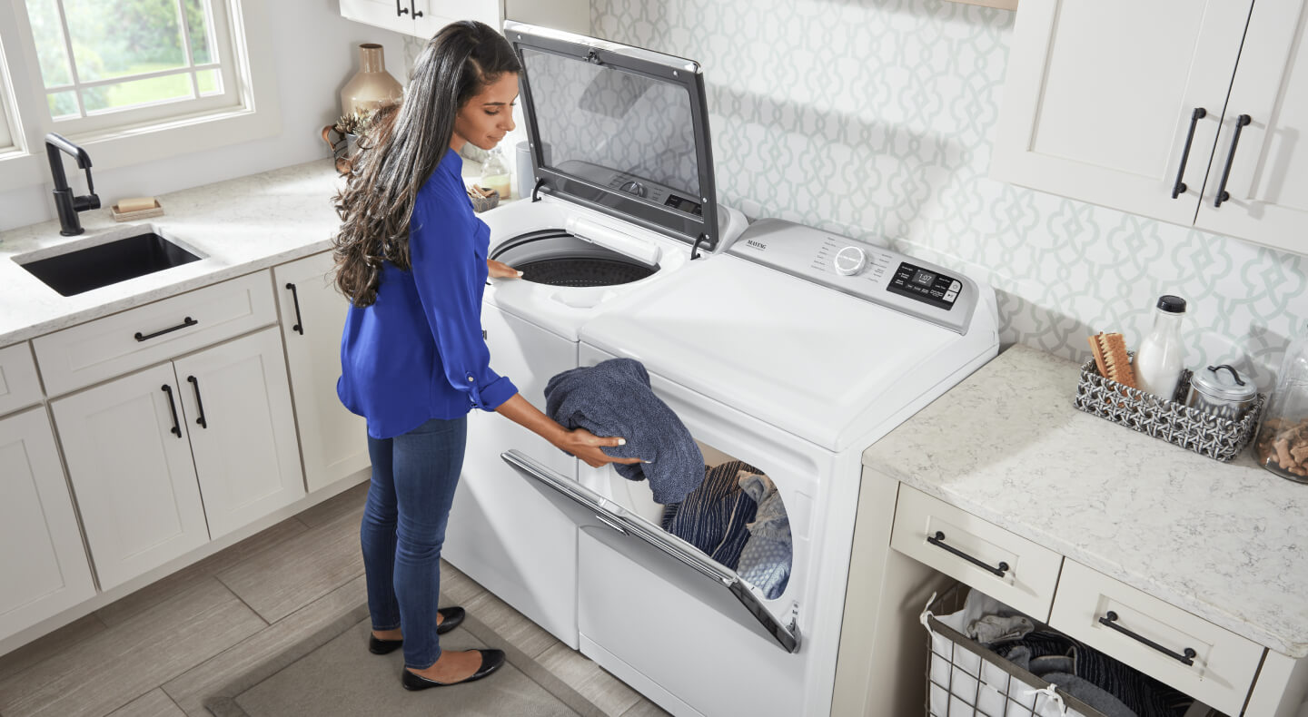 Person loading clothes into dryer