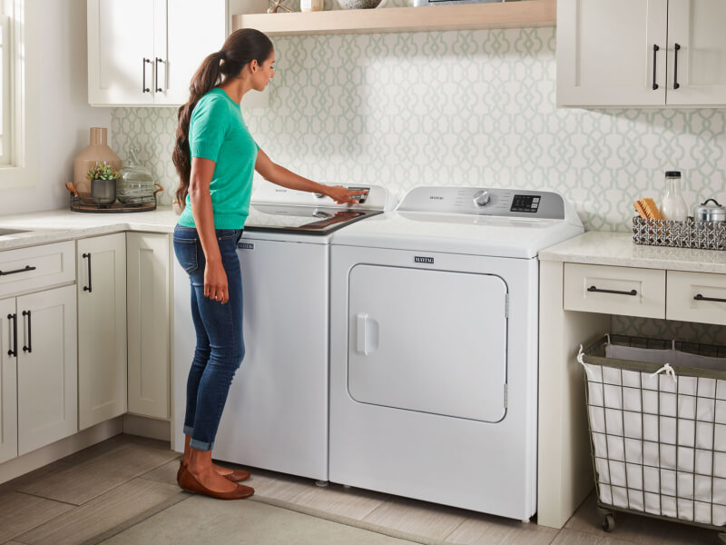 Person selecting a setting on a washing machine