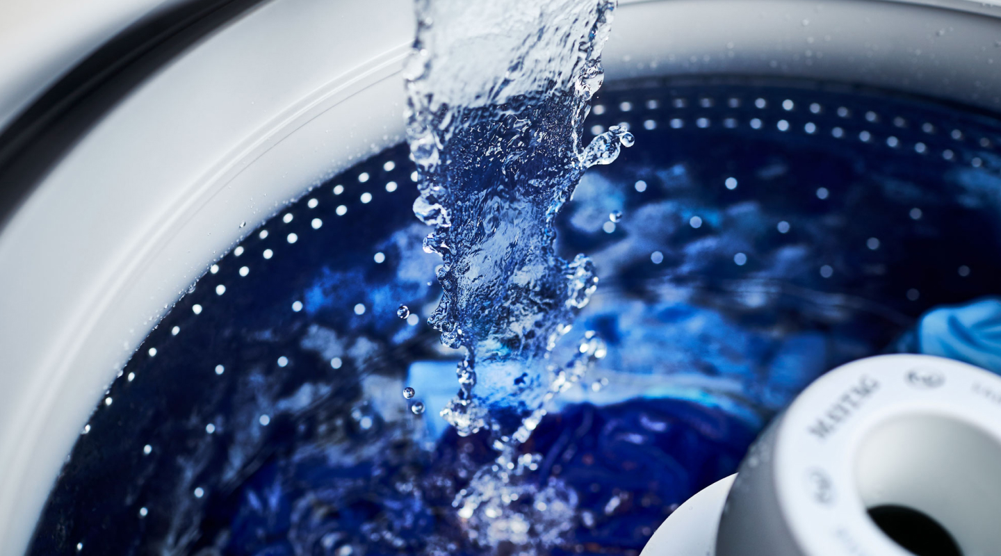 Close-up of water pouring into washer above agitator